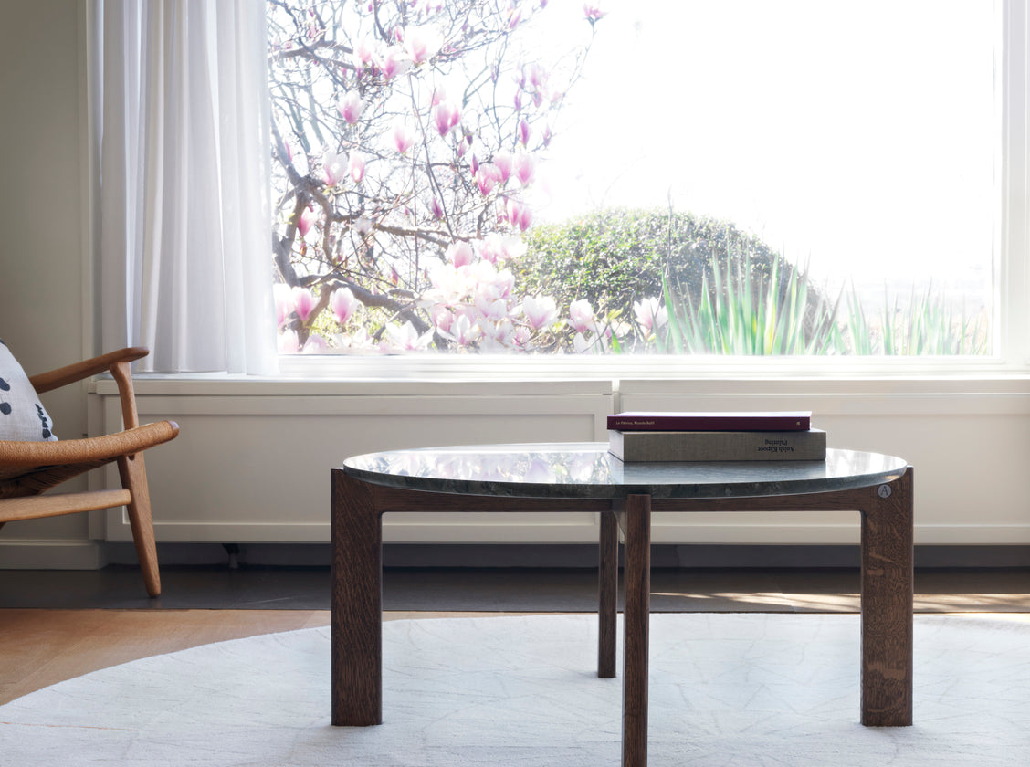 Designed by Daniel Lavonius Jarefeldt 2023.  Iris is a round coffee table with a simple, clean, and functional shape and descriptive details. The base has softly rounded corners where part of the legs embraces the tabletop.