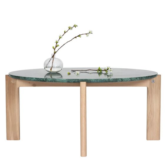 Designed by Daniel Lavonius Jarefeldt 2023.  Iris is a round coffee table with a simple, clean, and functional shape and descriptive details. The base has softly rounded corners where part of the legs embraces the tabletop.