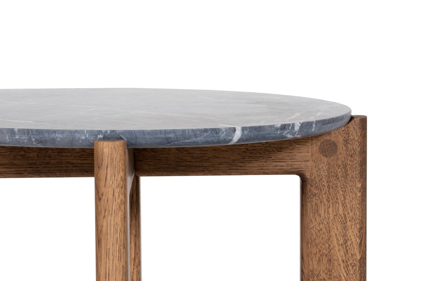Designed by Daniel Lavonius Jarefeldt 2023.  Iris is a round coffee table with a simple, clean, and functional shape and descriptive details. The base has softly rounded corners where part of the legs embraces the tabletop.