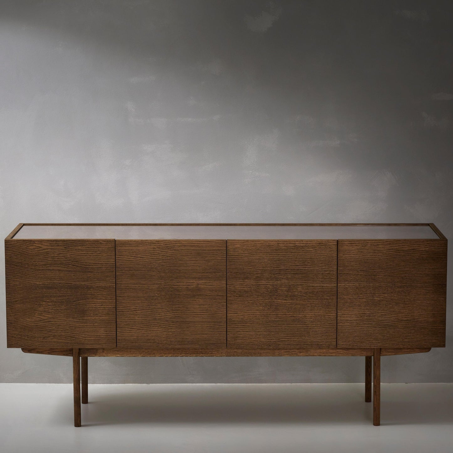 Designed by Broberg and Ridderstråle. Storage in oak veneer with a wooden base and glass on wood top. Cabinet with two compartments and four doors. One shelf in each compartment.