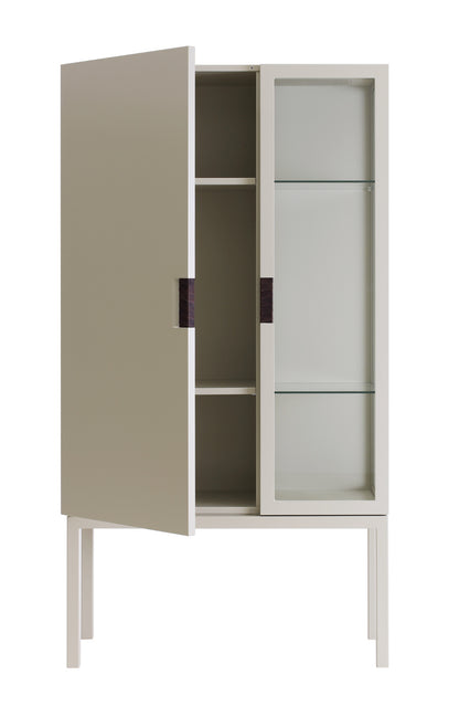 Designed by Anya Sebton and Eva Lilja Löwenhielm 2014.  Glass cabinet in lacquered MDF, stand in lacquered metal. The left side has a covered door and a covered side with two lacquered shelves and the right side has a glass door and a glass side with two glass shelves. Doors have twined leather handles. 