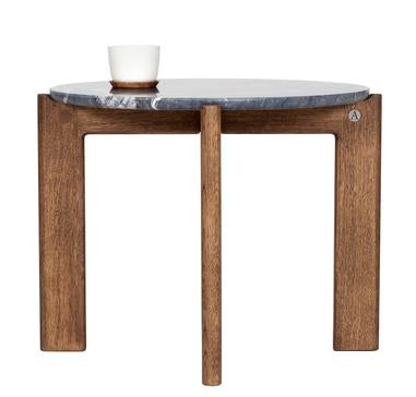 Designed by Daniel Lavonius Jarefeldt 2023.  Iris is a round coffee table with a simple, clean, and functional shape and descriptive details. The base has softly rounded corners where part of the legs embraces the tabletop. 