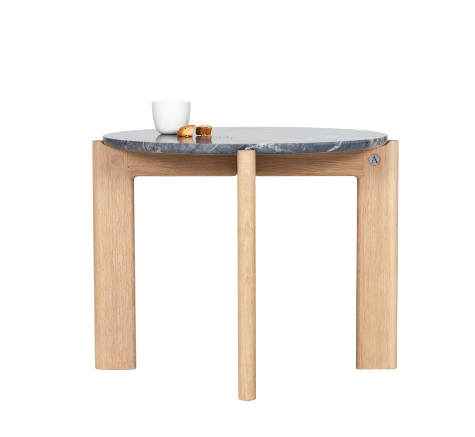 Designed by Daniel Lavonius Jarefeldt 2023.  Iris is a round coffee table with a simple, clean, and functional shape and descriptive details. The base has softly rounded corners where part of the legs embraces the tabletop. 