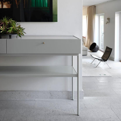 Designed by Broberg and Ridderstråle 2015.  Console in lacquered MDF with 2 drawers with brass knobs and a lacquered MDF shelf. Stand in lacquered metal and top in stone or oak veneer. 